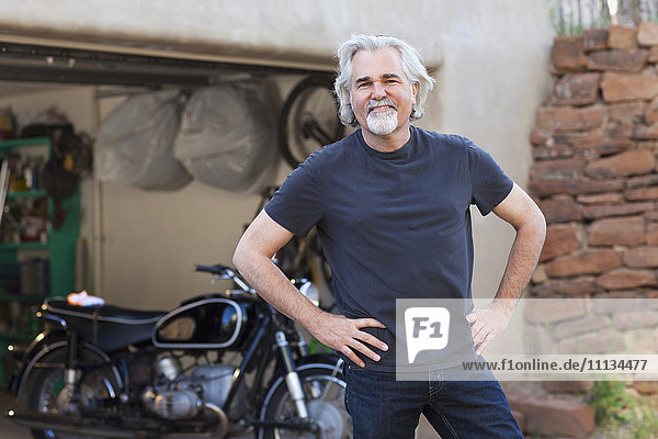 Kaukasischer Mann in Einfahrt mit Motorrad