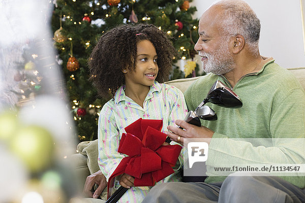 Afroamerikanische Enkelin gibt Großvater Weihnachtsgeschenk