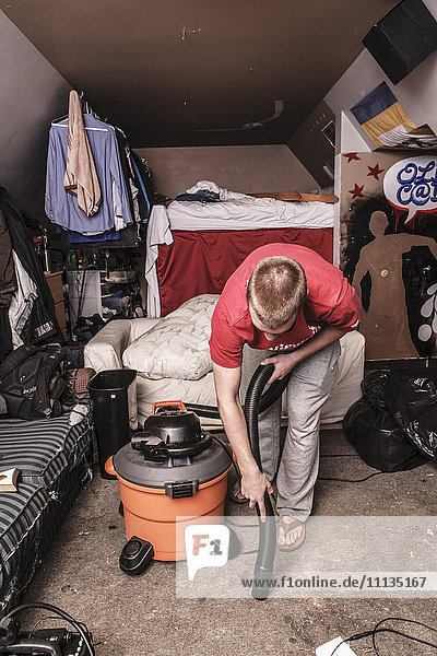 Caucasian man vacuuming floor