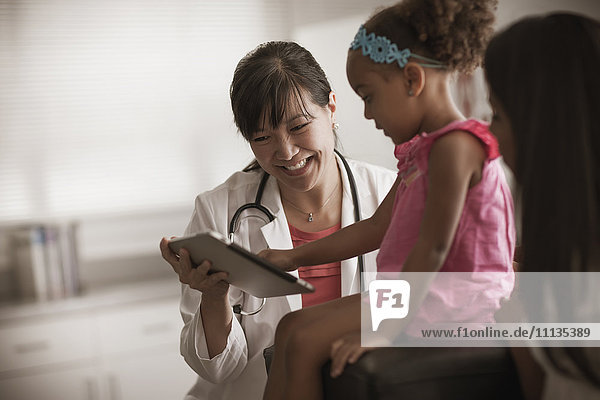 Arzt zeigt Mädchen digitales Tablet