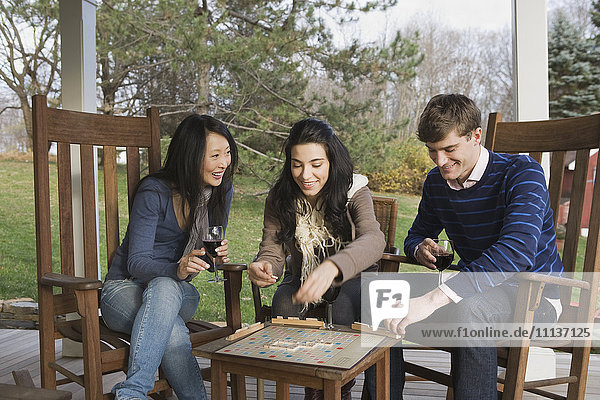 Freunde spielen Scrabble auf der Veranda