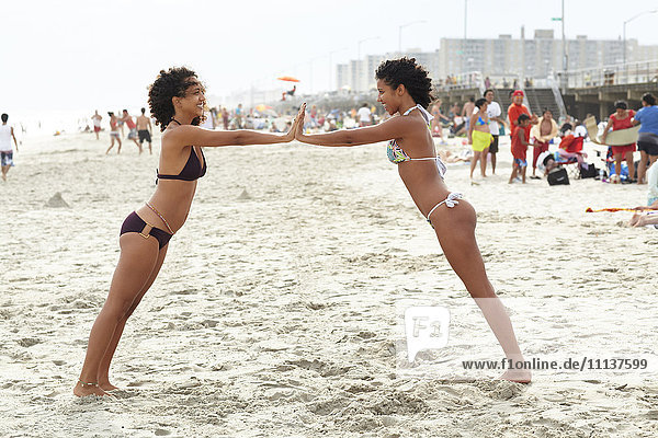 Mixed race friends playing on beach