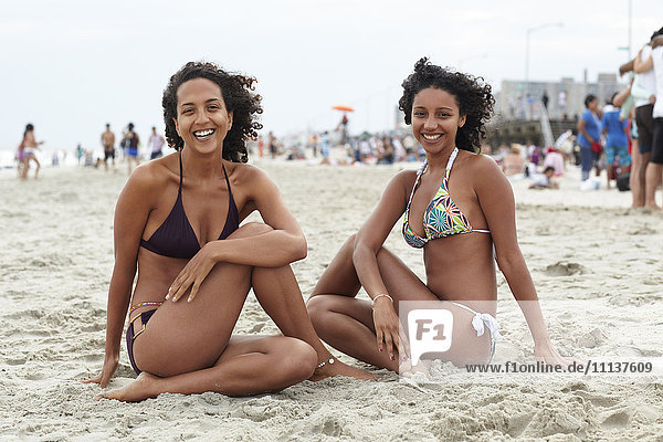 Mixed race friends sitting on beach