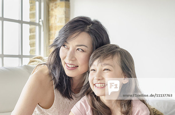 Mother and daughter smiling on sofa