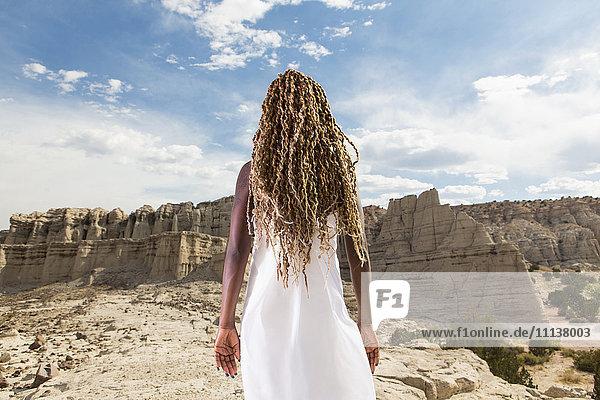 African American woman examining rock formations Santa Fe New Mexico United States