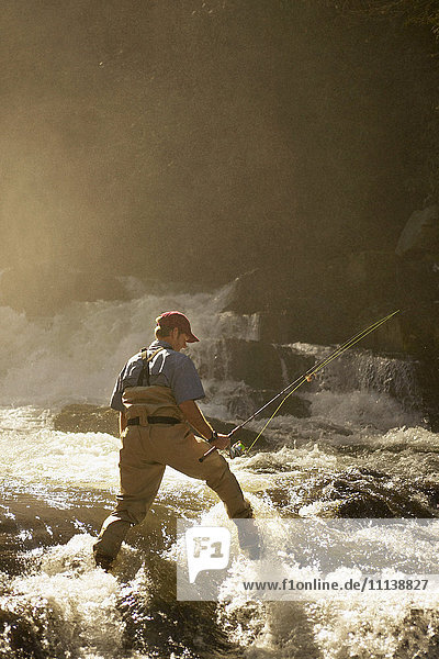 Mann beim Fliegenfischen im Fluss