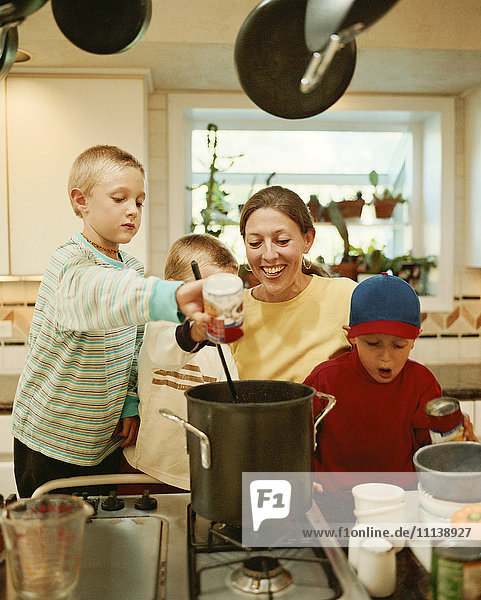 Kaukasische Mutter und Söhne bereiten Essen zu
