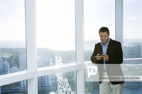 Hispanic businessman using cell phone