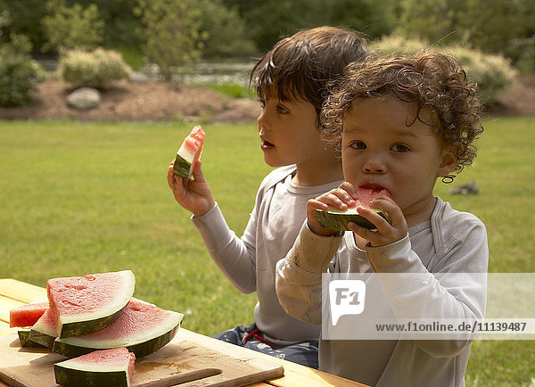 Gemischtrassige Kinder essen Wassermelone