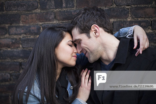 Couple hugging against wall