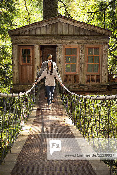 Couple on walkway of remote tree house