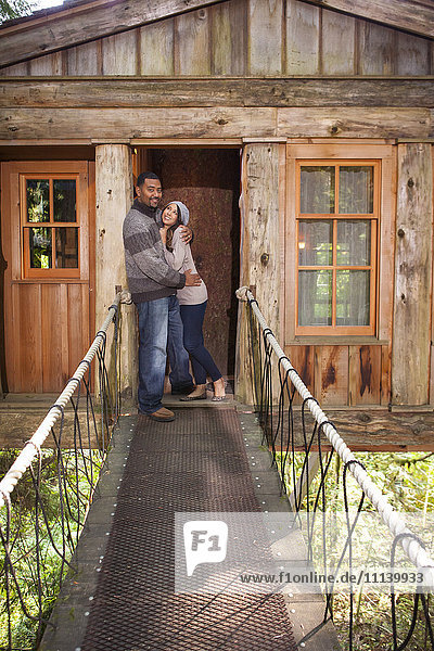 Ehepaar auf dem Gehweg eines abgelegenen Baumhauses