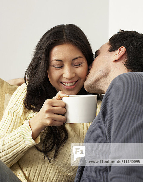 Ehemann küsst Frau und trinkt Kaffee