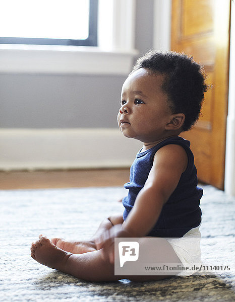 African American baby sitting on floor