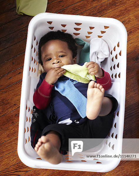 African American baby laying in laundry basket