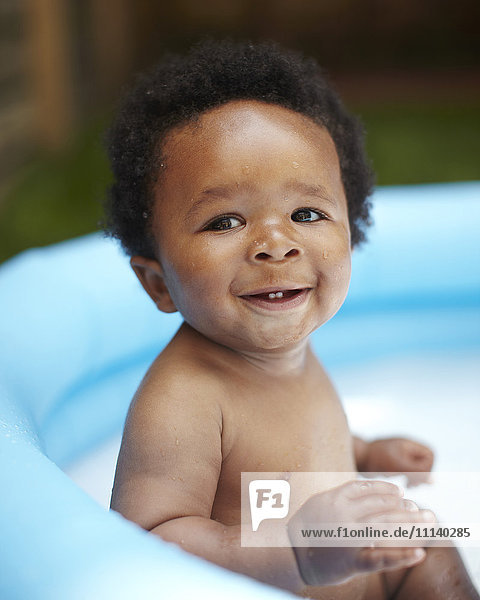Smiling African American baby in swimming pool