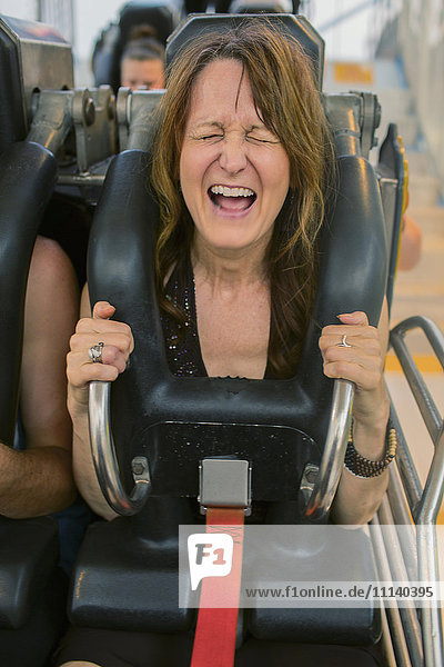 Caucasian woman shouting on roller coaster