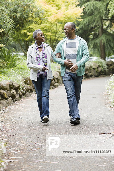 Smiling African American couple walking in park