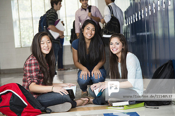 Gymnasiasten  die zusammen im Korridor sitzen