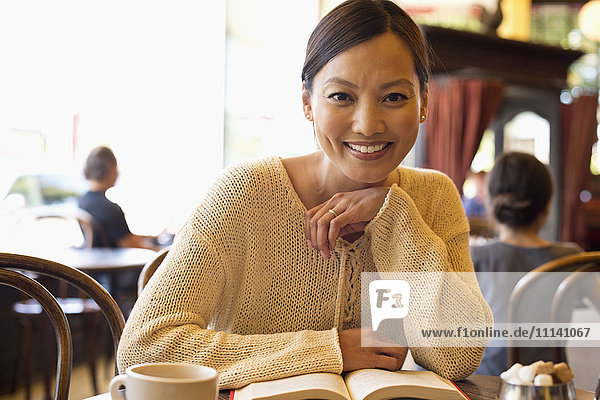 Philippinische Frau liest Buch in einem Cafe