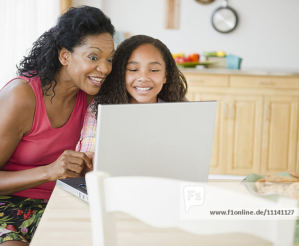 Mutter und Tochter schauen auf den Laptop