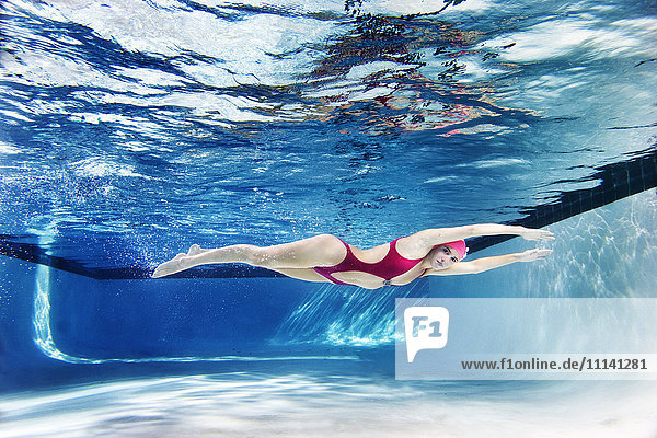 Kaukasische Frau schwimmt unter Wasser