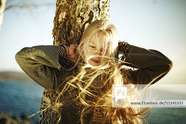 Kaukasisches Mädchen Haar wird durch den Wind in der Nähe von Meer geblasen