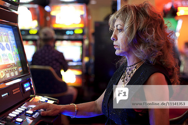 Kaukasische Frau spielt Spielautomat im Kasino