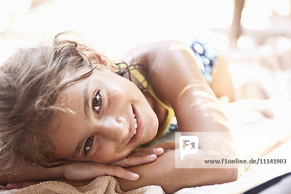 Lächelndes gemischtrassiges Mädchen beim Sonnenbaden