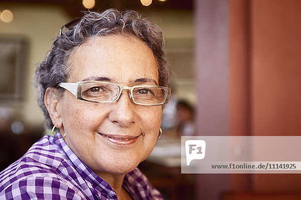 Lächelnde hispanische Frau mit Brille