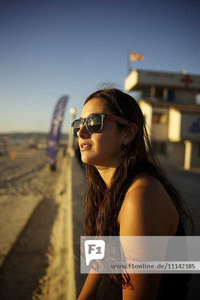 Frau mit Sonnenbrille genießt den Strand
