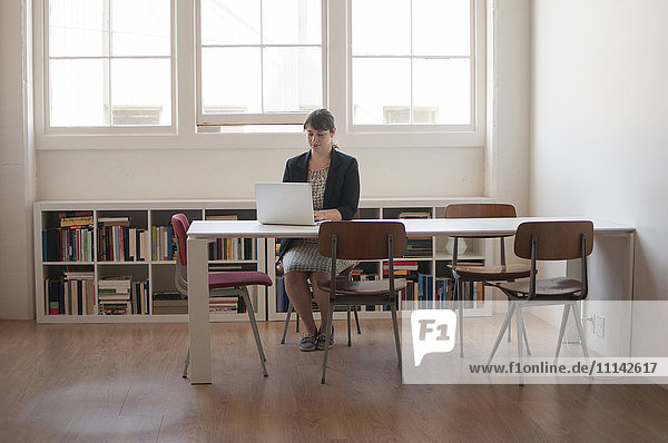 Caucasian businesswoman working on laptop in office