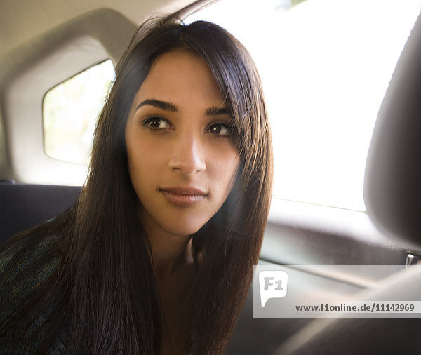 Frau sitzt auf dem Rücksitz eines Autos