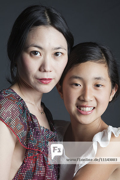 Asiatische Mutter und Tochter umarmen sich