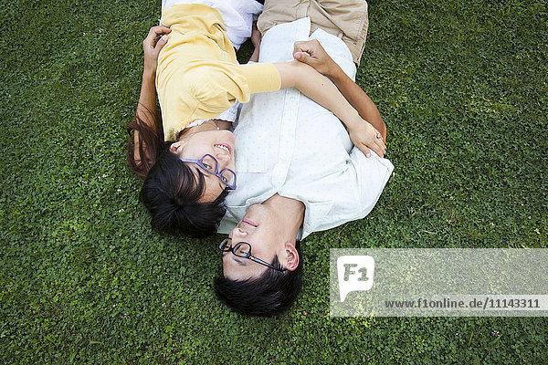 Asiatisches Paar umarmt auf Gras