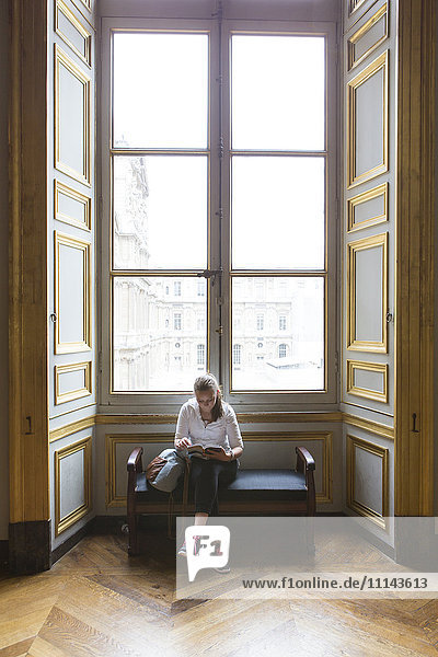 Caucasian teenage girl studying in ornate window at Louvre Museum  Paris  Ile De France  France
