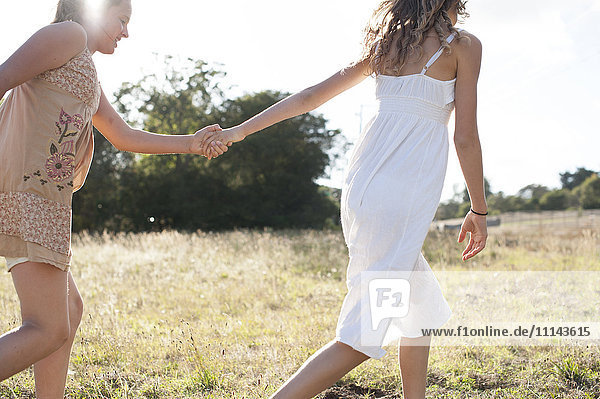 Girls holding hands in field