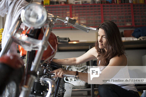 Mechaniker repariert Motorrad in der Werkstatt