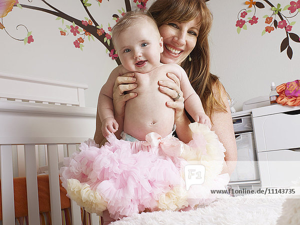 Mother holding baby girl in tutu