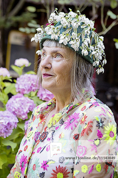 Stilvolle ältere kaukasische Frau mit geblümter Kappe