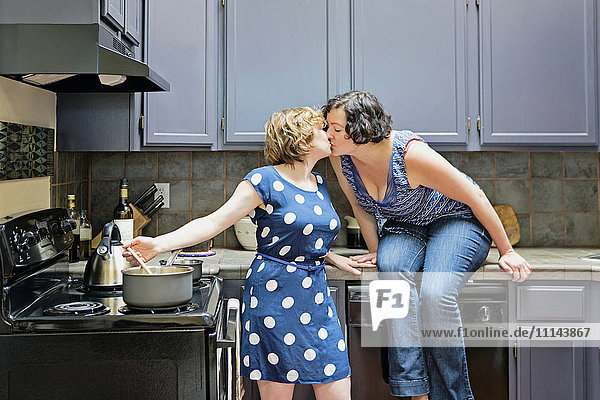 Lesbisches Paar beim Kochen in der Küche