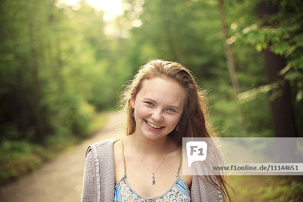 Caucasian girl smiling on forest path