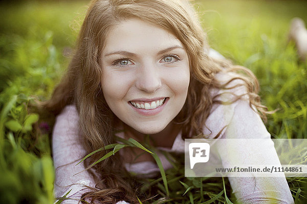 Smiling woman laying in rural field