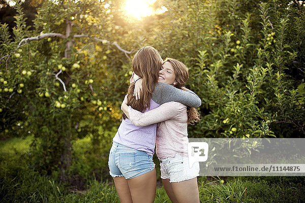 Caucasian women hugging in rural field