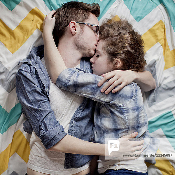 Hohe Winkel Ansicht von kuschelnden Paar auf dem Bett