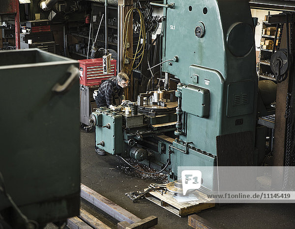 Caucasian man using machinery in workshop