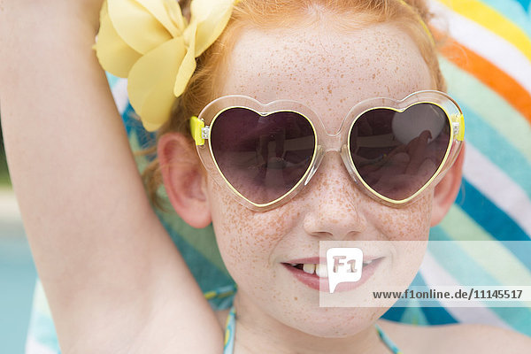 Close up of Caucasian girl wearing heart-shaped sunglasses
