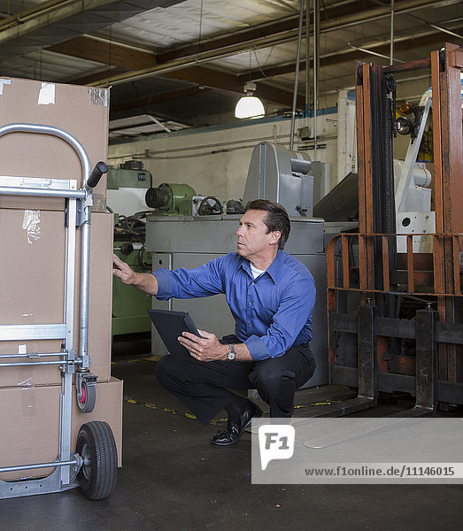 Caucasian businessman examining boxes in warehouse