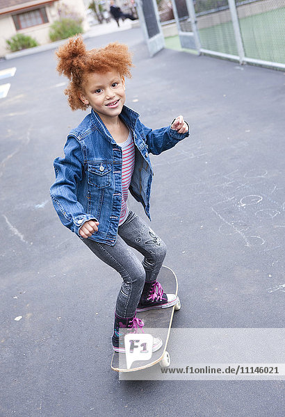 Girl riding skateboard in urban park