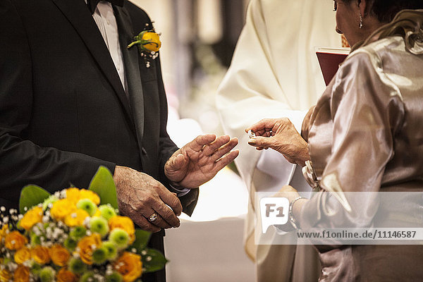 Senior couple exchanging rings at wedding